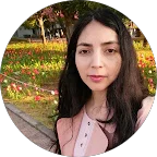 Mujer joven de cabello largo y oscuro, al aire libre en parque con flores y árboles.